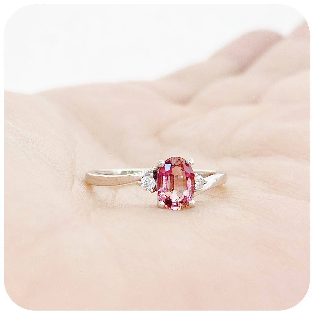 Oval cut Pink Tourmaline and Moissanite Trilogy Ring with a Twist