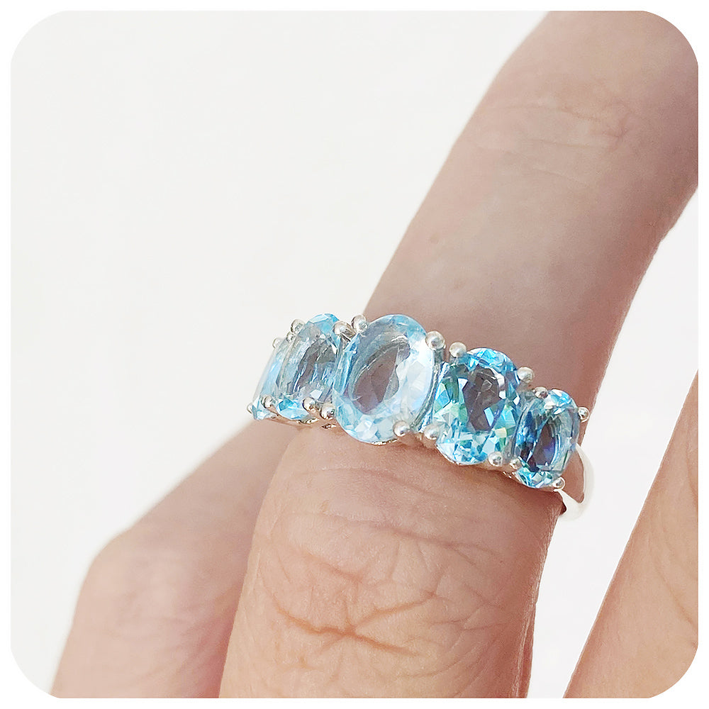 oval cut graduated sky blue topaz half eternity anniversary or birthstone ring