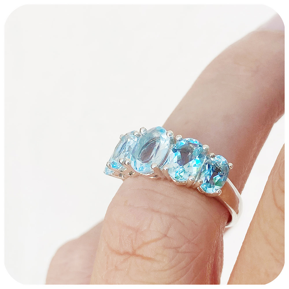 oval cut graduated sky blue topaz half eternity anniversary or birthstone ring