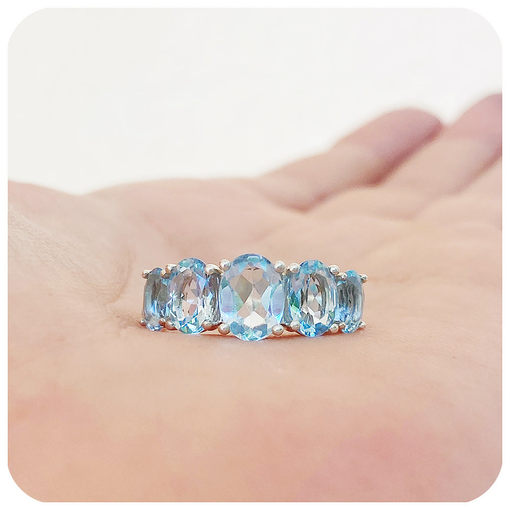 oval cut graduated sky blue topaz half eternity anniversary or birthstone ring