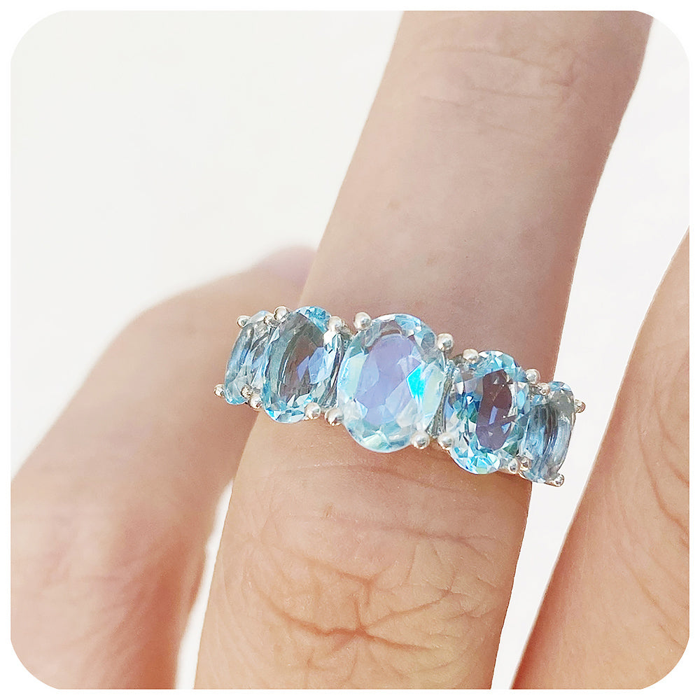 oval cut graduated sky blue topaz half eternity anniversary or birthstone ring