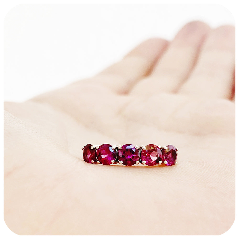 pinkish red rhodolite garnet half eternity ring with round cut stones