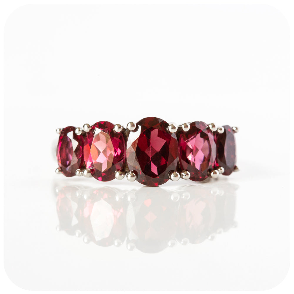oval cut pink-ish red rhodolite garnet half eternity anniversary ring