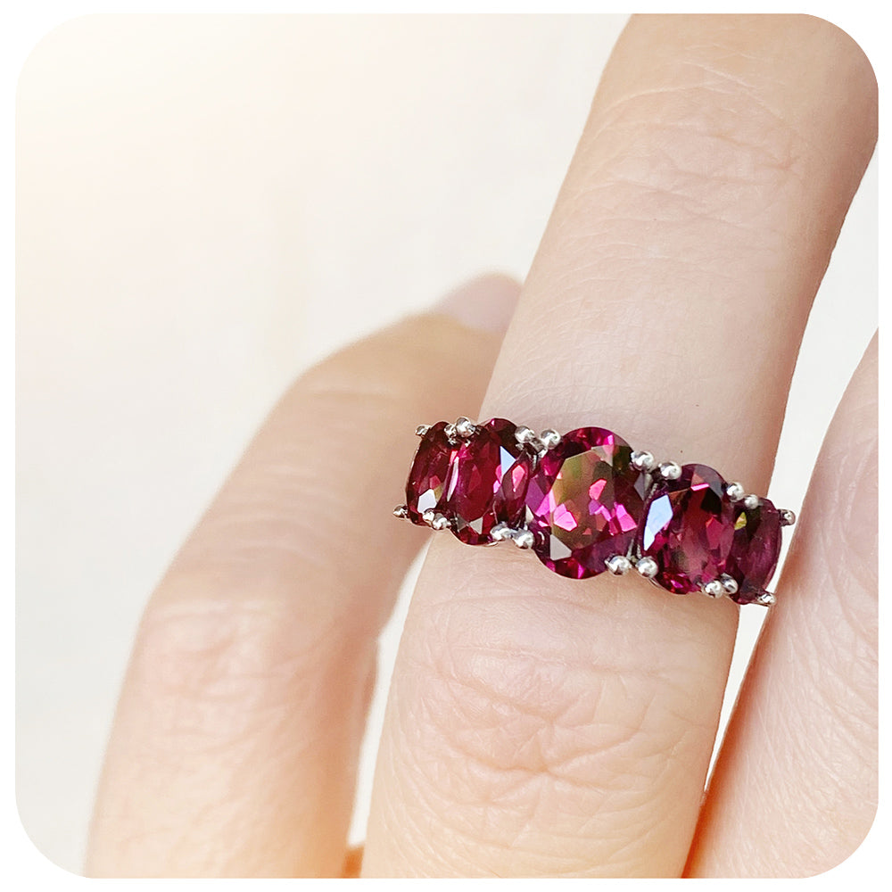 oval cut pink-ish red rhodolite garnet half eternity anniversary ring