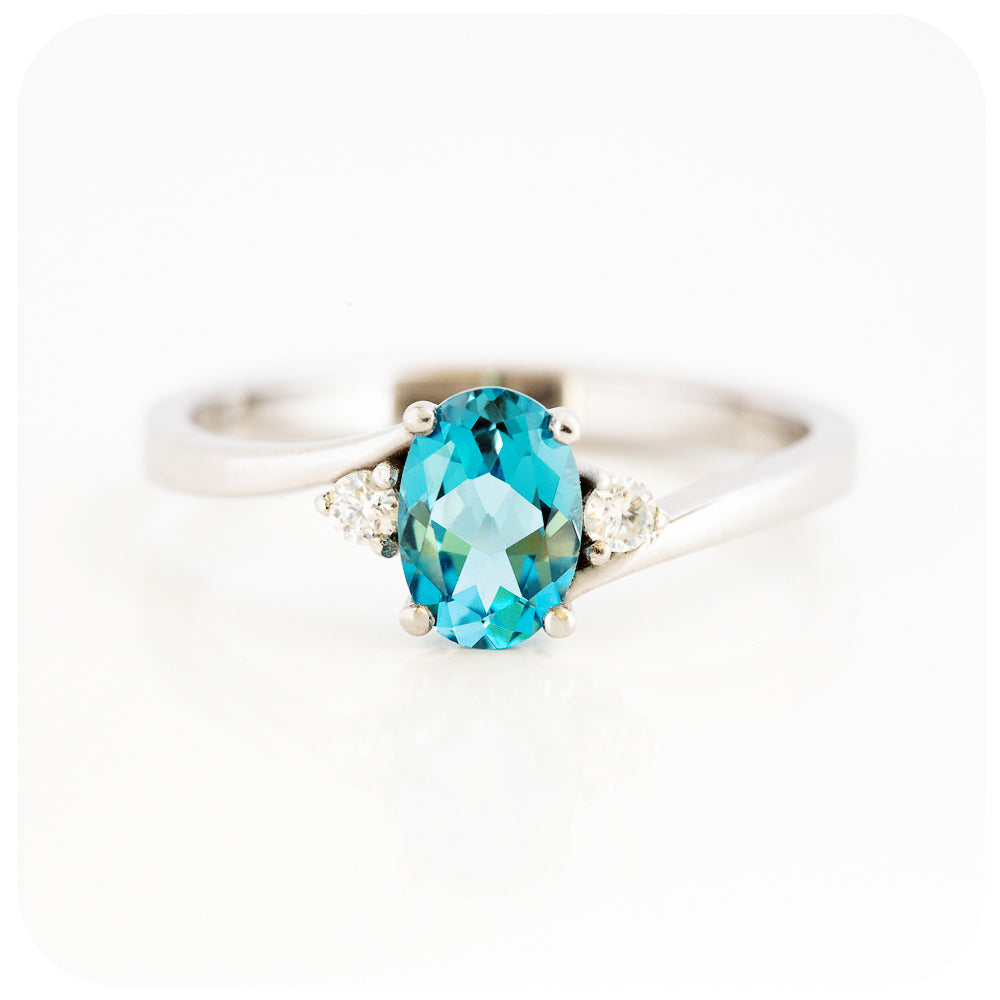 Oval cut Swiss Blue Topaz and Moissanite Trilogy Ring with a Twist